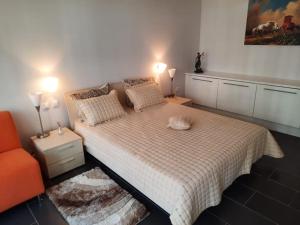 奥布佐尔Yoo Bulgaria Apartments -c306的一间卧室配有一张床和一张橙色椅子
