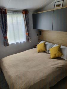古德瑞同Devon holiday的一间卧室配有一张带黄色枕头的大床