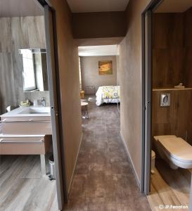 罗巴热瑟Logis Hôtel Beau Site的一间带水槽的浴室和一张位于客房内的床