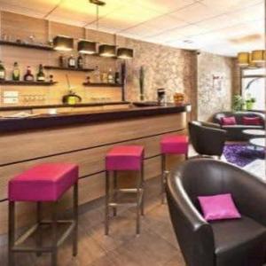 勒马尔奇奥·维勒Logis Hotel Restaurant des Voyageurs的吧台前有粉红色凳子的酒吧