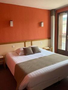勒马尔奇奥·维勒Logis Hotel Restaurant des Voyageurs的一间卧室设有一张大床和一个窗户。