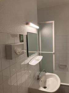 勒马尔奇奥·维勒Logis Hotel Restaurant des Voyageurs的一间带水槽和镜子的浴室