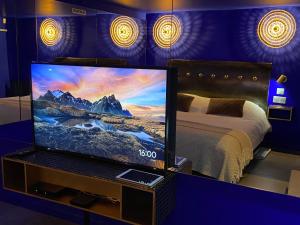 里尔Private Room & Spa avec jacuzzi privatif的客房内的电视,配有床和床