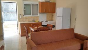 耶尼翁Armonia Nakas的厨房配有沙发、桌子和冰箱。