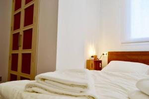 瓦伦西亚Hola Valencia - Holiday Apartments的一间卧室配有一张带白色床单的床和一扇窗户。