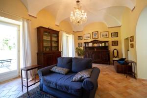 卡尼洛瑞维拉La loggia dei frati的客厅配有蓝色的沙发和吊灯。