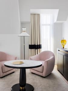 巴黎Kimpton - St Honoré Paris, an IHG Hotel的客厅配有粉红色的椅子和桌子
