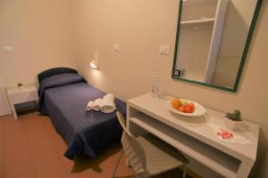 里米尼费多拉里米尼酒店的一间房间,配有一张床和一张桌子,还有一碗水果