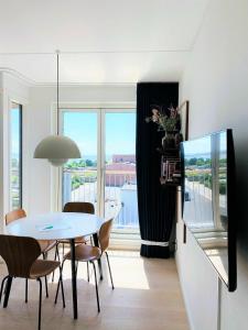 哥本哈根ApartmentInCopenhagen Apartment 1453的一间带桌椅和窗户的用餐室