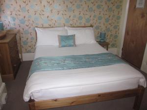 海斯廷斯The Old Town Bed and Breakfast的卧室配有白色的大床,并拥有蓝色的鲜花