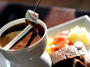 Bouth鲁斯兰泳池酒店的一杯咖啡,在一盘食物旁边加汤匙