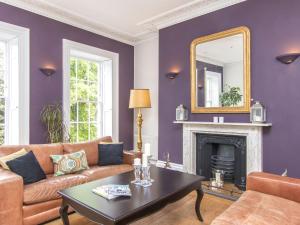 布里斯托3 Berkeley Square Guesthouse的客厅设有紫色墙壁和镜子