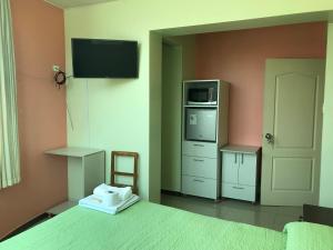 万卡约Rooms MD y FS的一间卧室设有一张带微波炉的床和一台电视。