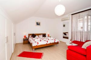 杜布罗夫尼克艾拉公寓酒店的一间卧室配有一张床和一张红色的沙发