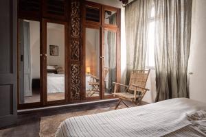 塔里法Eole Tarifa Apartments的一间卧室配有一张床、一把椅子和镜子