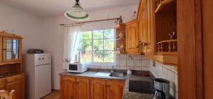 蒂哈拉费Casa Lulu的厨房配有水槽、冰箱和窗户。