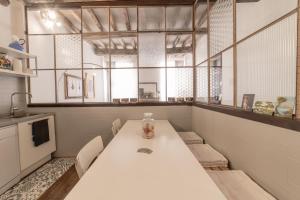 摩德纳casa sangiacomo quattro的厨房配有白色的桌椅和窗户。