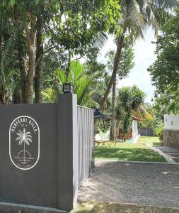 阿杭格默Kanferri Villa的棕榈树度假村入口处的大门
