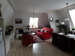哈林亨Het Speijerhuis的客厅配有红色的沙发和桌子