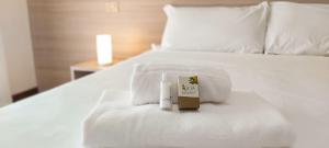 索托马里纳Hotel Ammare的一张带温度计的白色床和一本书