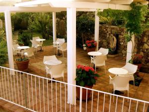 卡洛福泰品皮娜别墅酒店的庭院配有白色的桌椅和植物