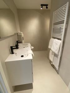 KnokkeLes Cigognes的浴室设有白色水槽和镜子