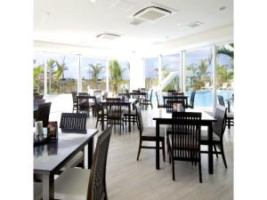 丰见城市HOTEL GranView Garden OKINAWA - Vacation STAY 44961v的用餐室设有桌椅和窗户。