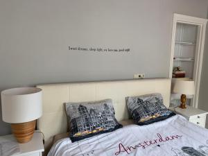 埃丹"De Walvisch", appartement in authentieke boerderij的一间卧室配有一张带两个枕头的床