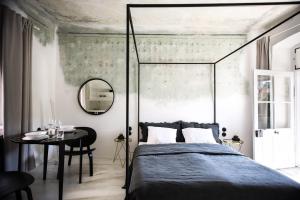 捷克克鲁姆洛夫Domeček / Tiny House的一间卧室配有一张床、一张桌子和一面镜子