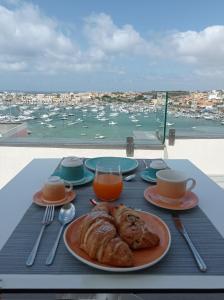 兰佩杜萨B&B Giro Di Boa的一张桌子,上面放着一盘食物,享有海港的景色