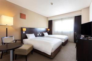 弘前市ART 弘前城市酒店的酒店客房设有两张床和电视。