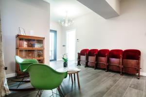 科莫In Centro Luxury Rooms的一间设有一排红色椅子的等候室
