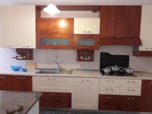 阿谢亚Casa Ester的厨房配有白色橱柜、水槽和柜台。