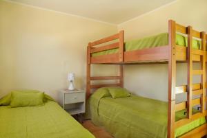 巴伊亚英格莱萨Moderna Casa Nueva - Bahía Inglesa的配有两张双层床的客房,配有绿色床单
