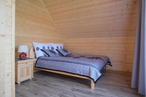 斯扎法拉瑞Domek na farmie的一间卧室设有一张床和木墙