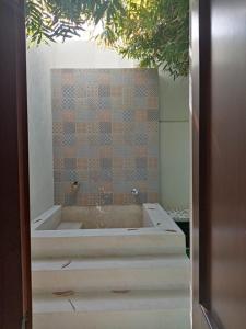 梅里达Hotel Las Monjas的带浴缸的浴室和瓷砖墙