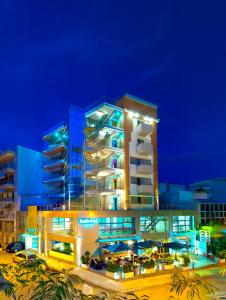 基尔基斯居留酒店的一座大建筑,晚上有蓝色的灯光
