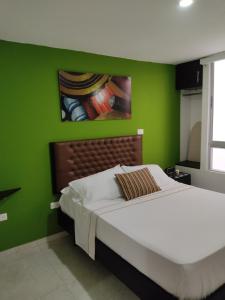 巴耶杜帕尔Escala Hotel的一间卧室设有一张带床铺的绿色墙壁