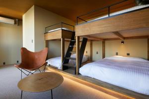 福冈mizuka Nakasu 5 - unmanned hotel -的一间卧室配有双层床、椅子和桌子
