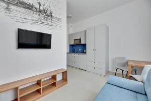 格丁尼亚Apartgdynia的客厅配有蓝色的沙发和电视