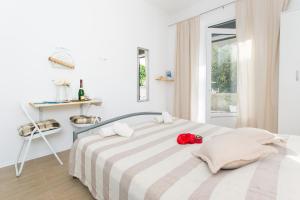 杜布罗夫尼克艾姆一室公寓的白色卧室,配有一张红色花卉床