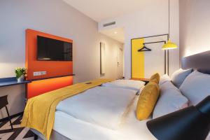斯图加特the niu Form的酒店客房配有一张带枕头的大型白色床。