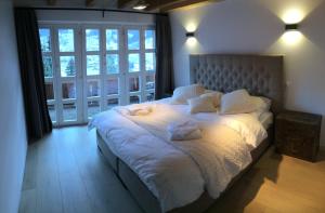 格林德尔瓦尔德Chalet M的卧室配有一张带白色床单和枕头的大床。
