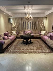 卡萨布兰卡Appartement de luxe的带沙发、桌子和吊灯的客厅