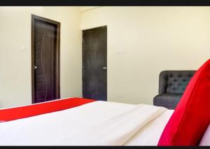 那格浦尔Hotel Relax Inn的卧室配有红色和白色的床和椅子