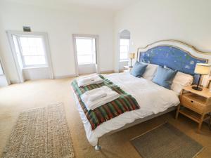 RameltonThe Ferry House的一间卧室配有一张大床和蓝色床头板