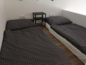 斯拉尼Fine apartment in centrum of Slaný with Aircondition的配有两张床铺的客房设有一张边桌