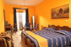 马罗尼亚Roxani Country House Resort的一间拥有橙色墙壁的卧室和一张位于客房内的床