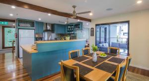 埃尔利海滩Airlie Guest House的厨房以及带木桌和椅子的用餐室。
