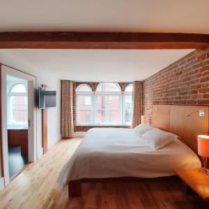 利物浦希望街设计酒店的一间卧室设有一张大床和砖墙
